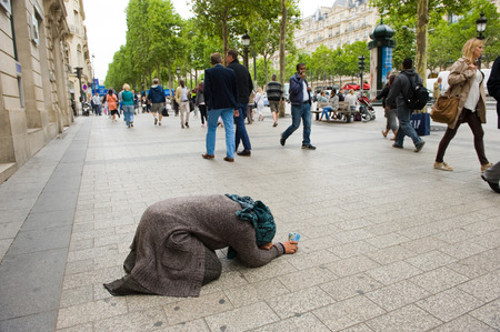 PARIS, FRANCE - JULY 28, 2015: A homeless woman is begging for money on the Champs-Elysees in Paris in Franceのeditorial素材