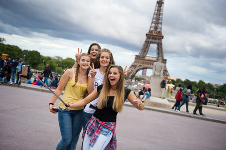 PARIS, FRANCE - JULY 27, 2015: Four girls are making a selfie in front of the eiffel tower in Paris in Franceのeditorial素材