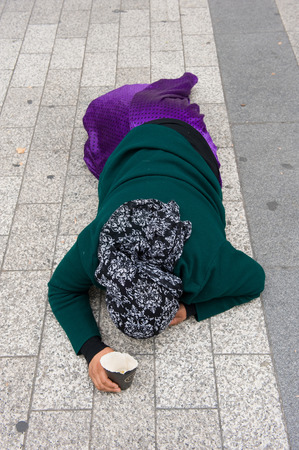 PARIS, FRANCE - JULY 28, 2015: A homeless woman is begging for money on the Champs-Elysees in Paris in Franceのeditorial素材