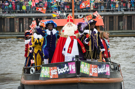ENSCHEDE, THE NETHERLANDS - NOV 14, 2015: The dutch Santa Claus called 'Sinterklaas' is arriving with his help Black Pete on a steamboat in a harbor in Holland.のeditorial素材