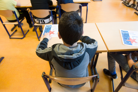 ENSCHEDE, NETHERLANDS - MAR 22, 2016: Child of 11 years old sitting behind his desk in a school class.のeditorial素材
