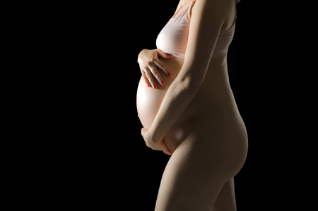 Pregnant woman is holding her bellyの写真素材
