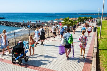 CANARY ISLAND TENERIFE, SPAIN - DEC 27, 2019: Tourits walking on the boardwalk along Playa El Duque. It ?? one of the most popular beaches on Tenerife.のeditorial素材