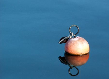 round objekt to ancre a boat is completely reflected in the waterの写真素材