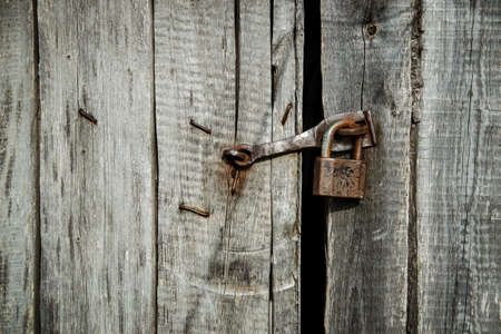 old iron padlock on the wooden door.の写真素材