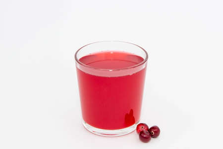 Red fruit drink from cranberries in a glass glass on a white background.の写真素材