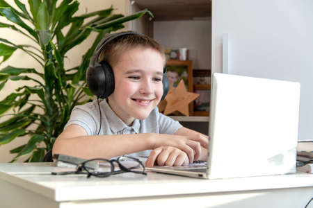 Distance learning online education. A schoolboy is studying at a computer at home and doing school...