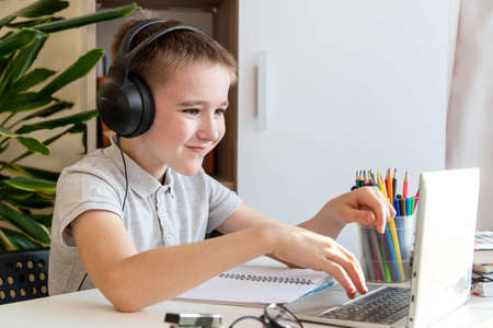 Distance learning online education. A schoolboy is studying at a computer at home and doing school...