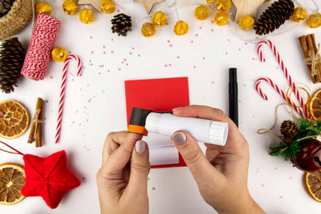 DIY step-by-step instructions for a Christmas card with children. Volumetric snowman on a postcard made of colored paper, glue and scissors. Step 7.の写真素材