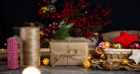 Gifts in craft paper and jute rope for Christmas on a wooden table.