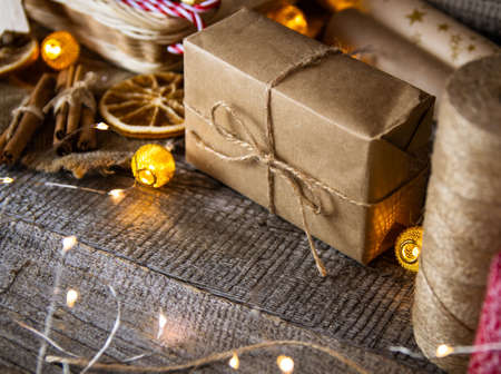 Gifts in craft paper and jute rope for Christmas on a wooden table.の写真素材