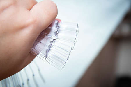 Transparent nail polish application palette clean in a woman's hand.