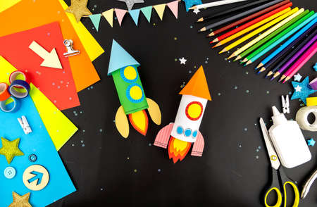 Craft space rocket made of colored paper in children's hands.の写真素材