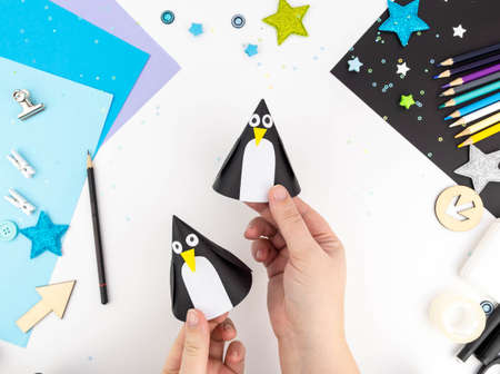 Step-by-step instruction of making a penguin out of paper with children.の写真素材