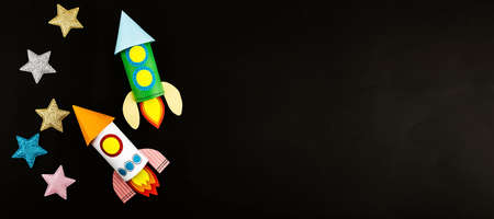 Craft space rocket made of colored paper in children's hands.の写真素材
