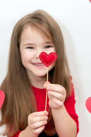 A heart on a stick in the hands of a childs girl. Concept Valentines Day and Children.の写真素材
