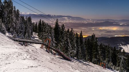 Poiana Brasov, Romania, The hearth of Transylvania, one of the most picturesque Europe`s ski resort.  Wooden chalets and spectacular ski slopes in the Carpathians. View at night.の写真素材