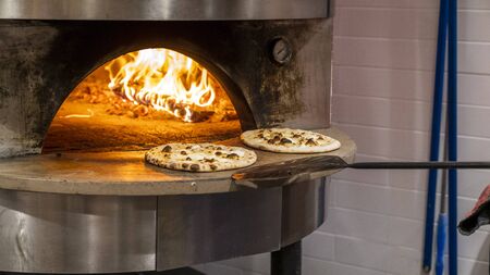 Pizza margherita in a wood oven. Cooking a margherita pizza in a wood oven