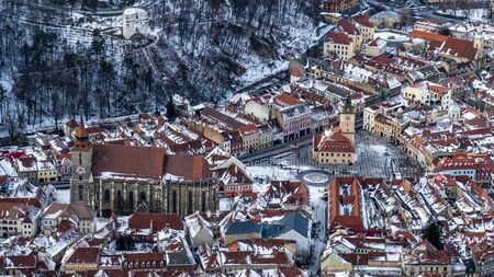 Brasov, Transylvania. Romania. Panoramic view of the old town and Council Square, Aerial twilight of the city covered with snow.の写真素材