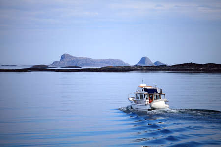 boat in norway sea with panorama view to mountains in the backgroundの写真素材