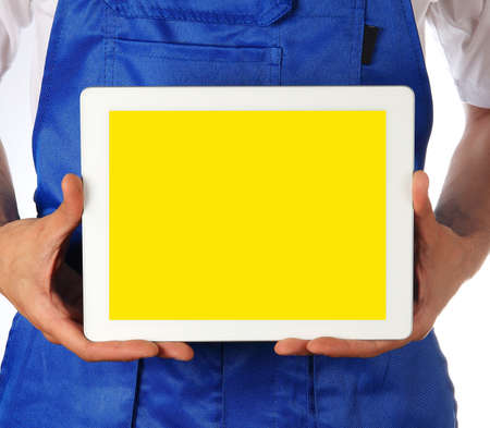 Worker in a blue costume is holding touchpad over white backgroundの写真素材