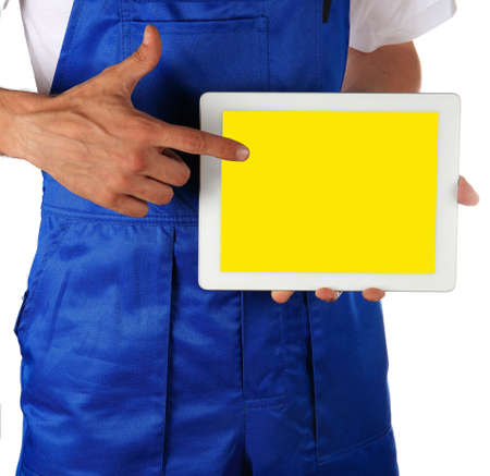 Worker in a blue costume is holding touchpad over white backgroundの写真素材