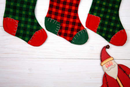 Christmas stocking on white wooden background and toy sana claus underの写真素材