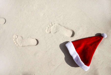 Santa hat and his trace on a beachの写真素材