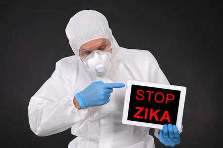 Researcher Holds Tablet with ZIKA Virus Word on Blackboard Backgroundの写真素材