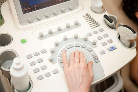 Doctor performing an ultrasound examination on specialized equipmentの写真素材