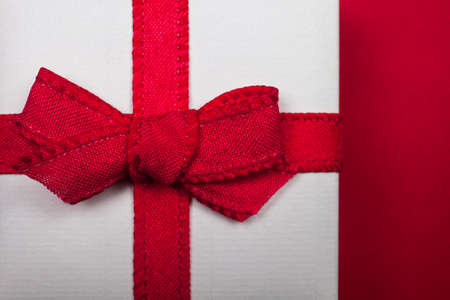 Little white gift box isolated on red backgroundの写真素材