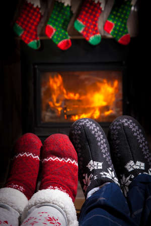 Christmas concept - family in front of fireplace. Two pairs of ornamented Christmas socks.の写真素材