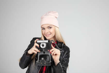 Portrait of pretty blond hair smileing young teenage hipster woman model with retro photo camera...