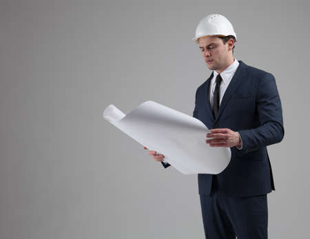 Portrait of a businessman in white helmet on gray backgroundの写真素材
