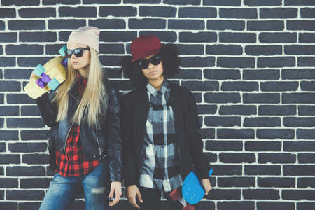 Studio lifestyle portrait of two best friends hipster girls going crazy and having great time together. Isolated on white background.の写真素材