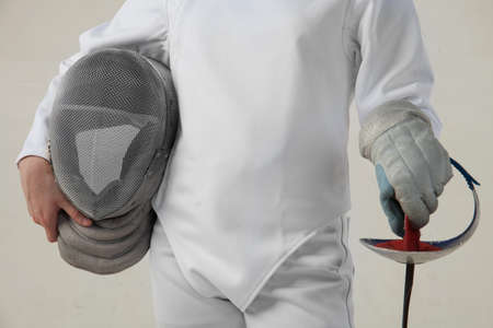 Female fencer hold the epee and rencer mask isolated on white backgroundの写真素材