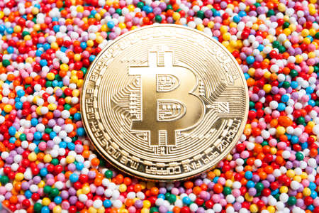 Golden Bitcoin coin on a colorful candy background close upの写真素材