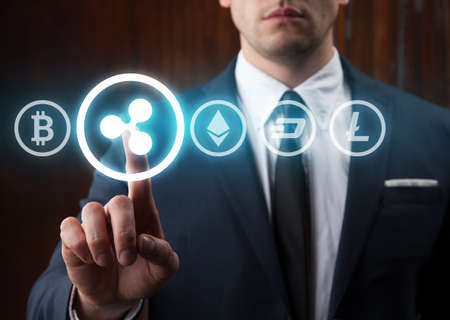Businessman pressing ripple icon choosing from other cryptocurrency. Bitcoin, ripple, litecoin,...
