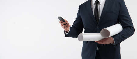 Portrait of a architect looks at smartphone on light gray backgroundの写真素材