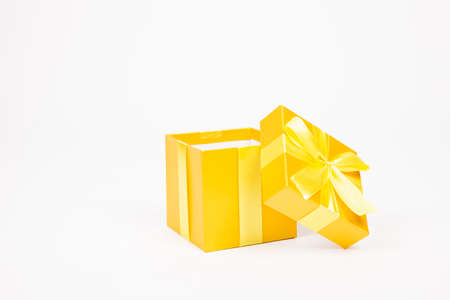 Golden gift box with yellow ribbon isolated on white backgroundの写真素材