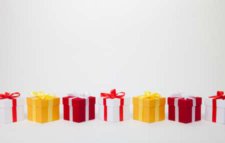 Christmas red and white and golden gift boxes stay in line with copy space. Isolated on whiteの写真素材