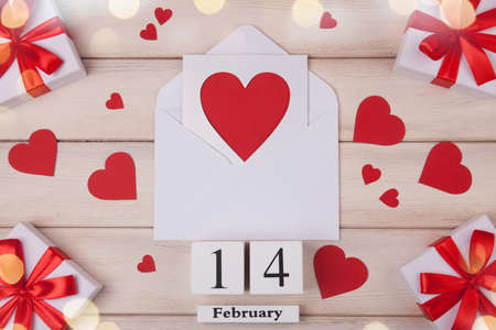 Wooden white background with red hearts, gifts, love envelope and wooden block calendar. The concept of Valentine Day. Top viev.の写真素材