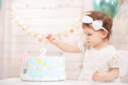 Little girls birthday party. Cute princess eat cake.の写真素材