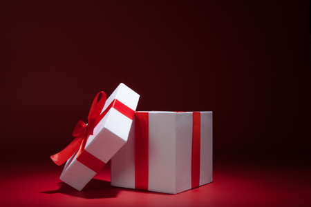 Opened white gift box on red background