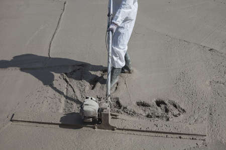 a worker levels the concrete surface of the basementの写真素材