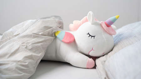 Unicorn sleeping in the bad. Close up.