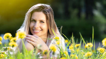 Young beautyful woman lies on the grass and smilingの写真素材