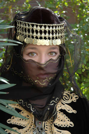 A girl wearing a black veil and head dress with golden adornmentsの写真素材