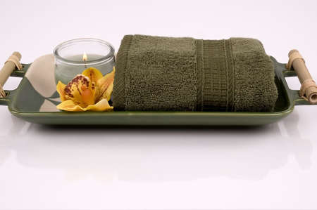Towel, candle and orchid on an oriental porcelain dishの写真素材