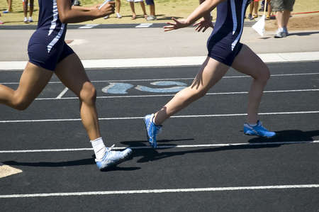Passing the baton during relay competitionの写真素材